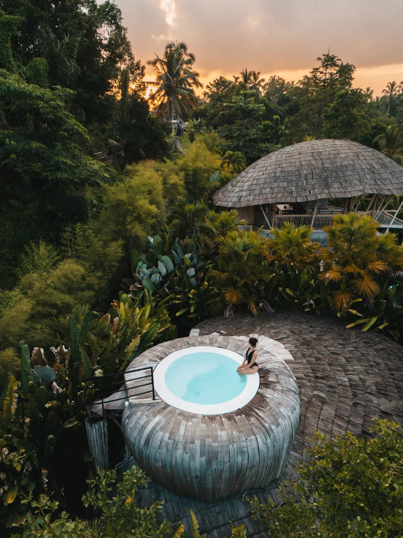 An aerial view of the bamboo villas and circular rooftop pool at Ecosix Bali